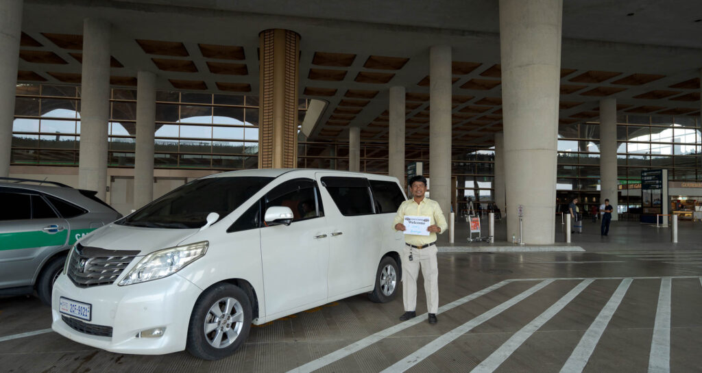 driver at phnom penh airport with toyota alphard vehicle at arrivals area
