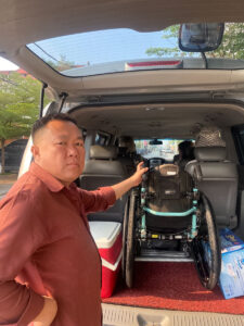 Driver assisting with wheelchair loading for accessible Angkor Wat tour