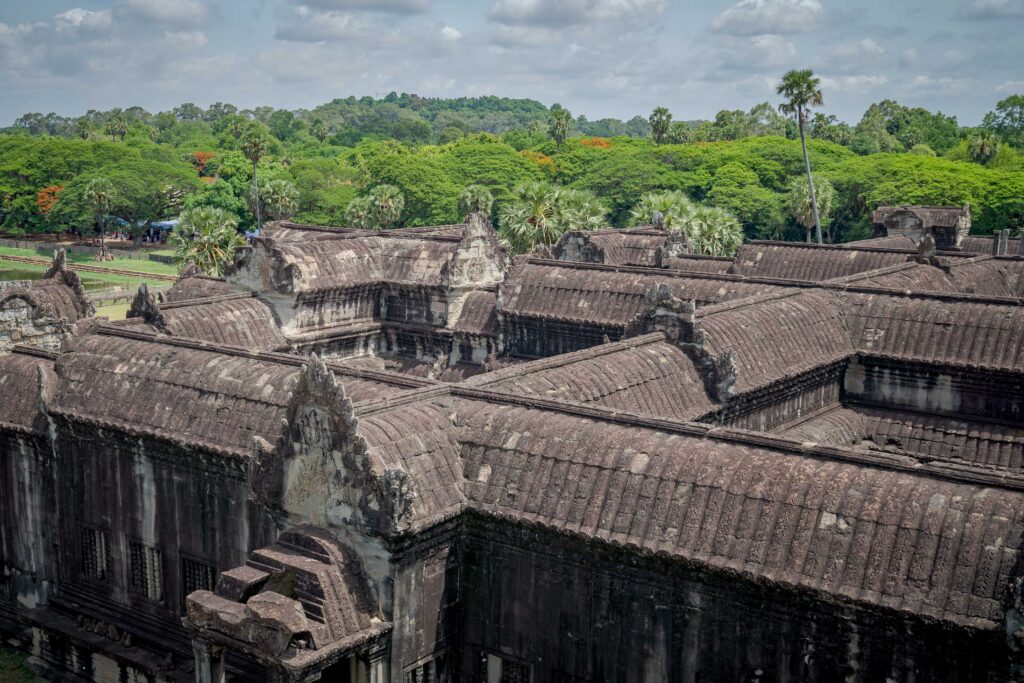 Elevated view looking down at the stone galleries and surrounding jungle canopy from the Bakan upper level of Angkor Wat