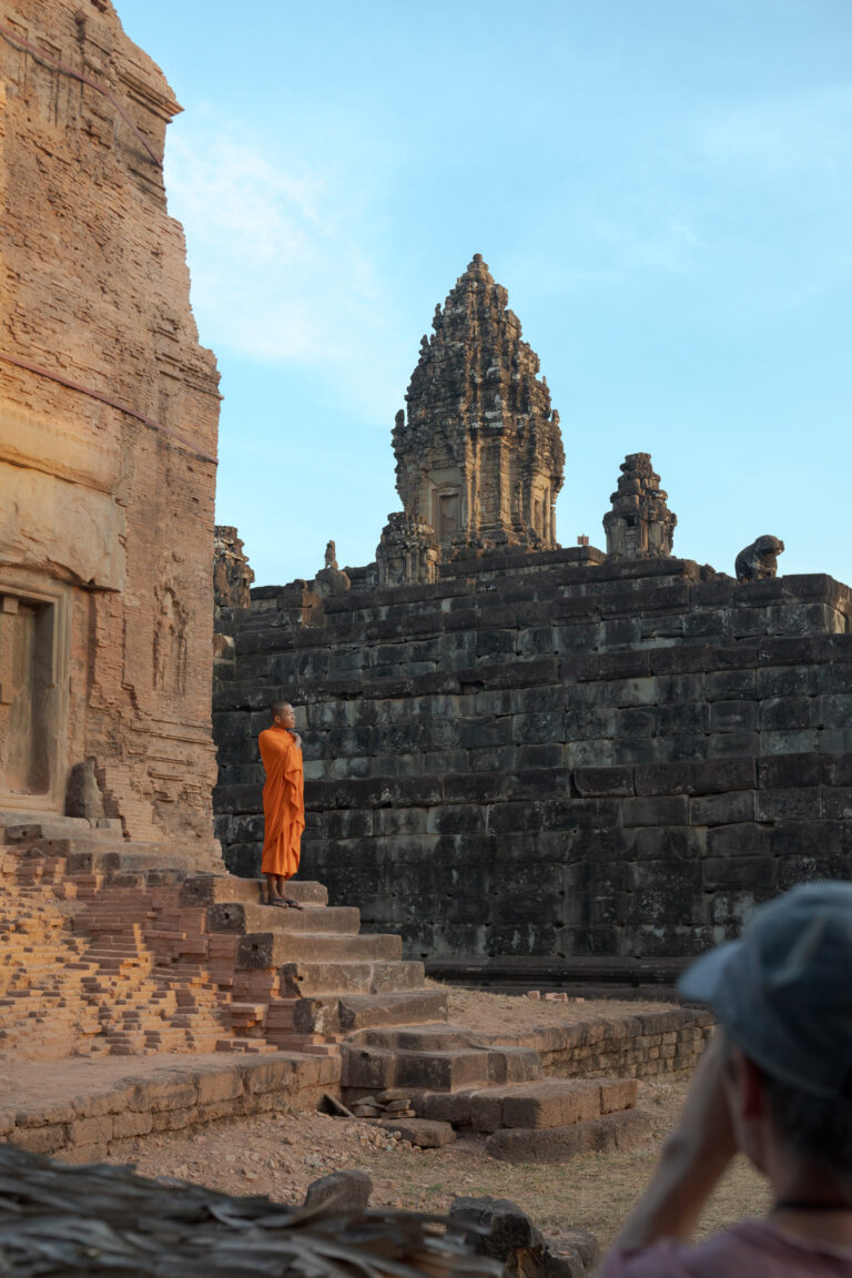 A Buddhist monk standing on the stepped sandstone tiers of Bakong temple, the main temple of the Roluos Group located 13 km east of Siem Reap.