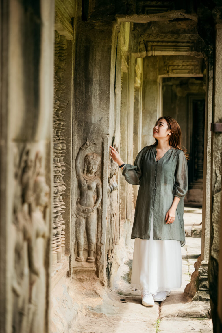 Tourist admiring Apsara dancer carvings captured by a professional Angkor Wat photographer