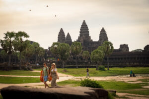 Tourists walking toward Angkor Wat temple across the main causeway in Siem Reap, Cambodia.