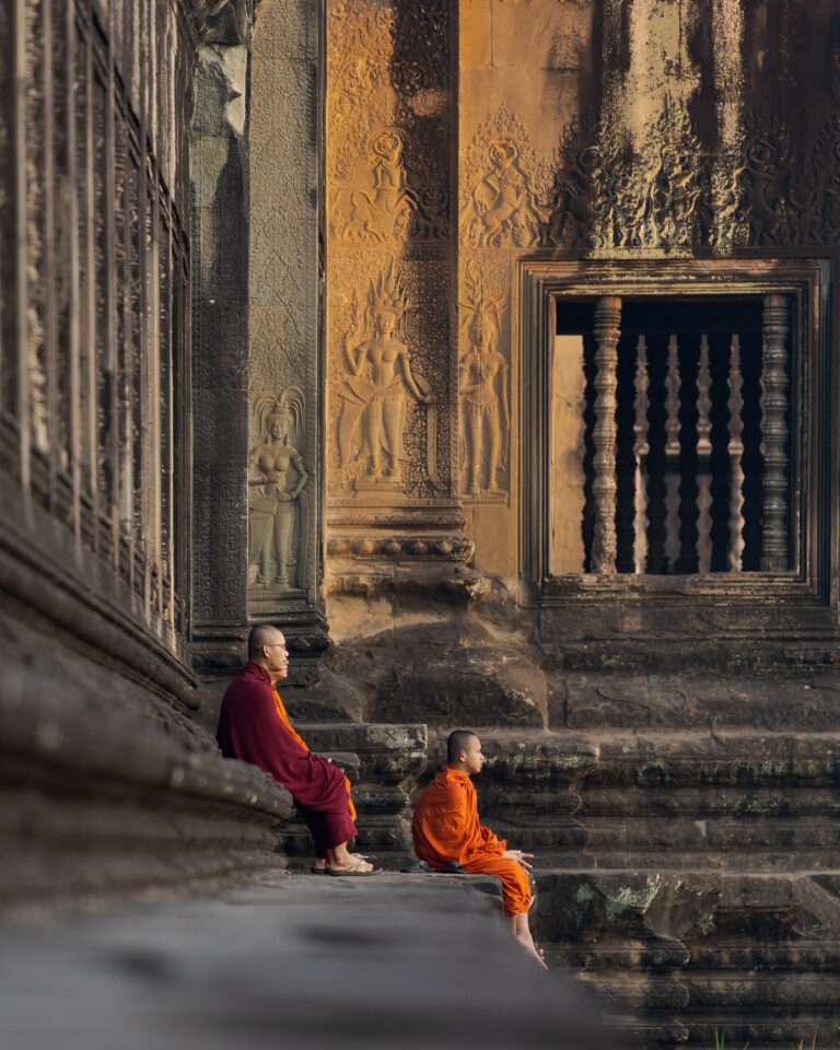 monks at angkor wat temple at sunrise