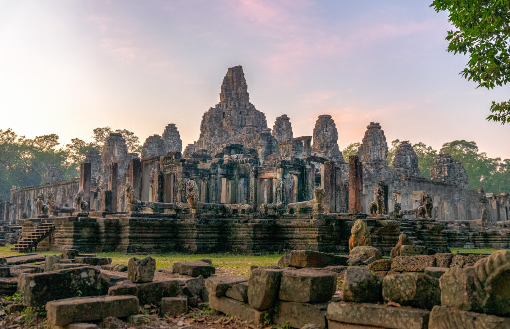 Bayon temple at Angkor Thom in the early morning, with its distinctive stone towers rising above the surrounding ruins.