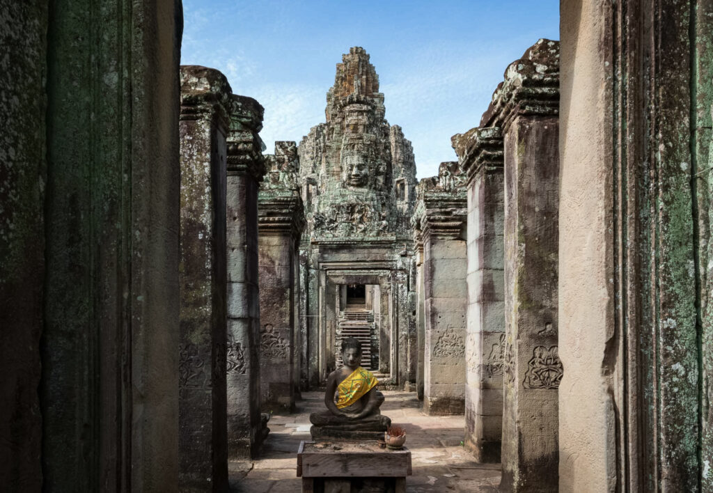 Buddha statue inside a stone corridor at Bayon Temple, Angkor Thom