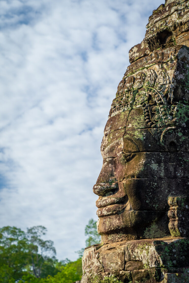 Close-up profile of a large carved stone face on one of the towers of Bayon temple at Angkor Thom.