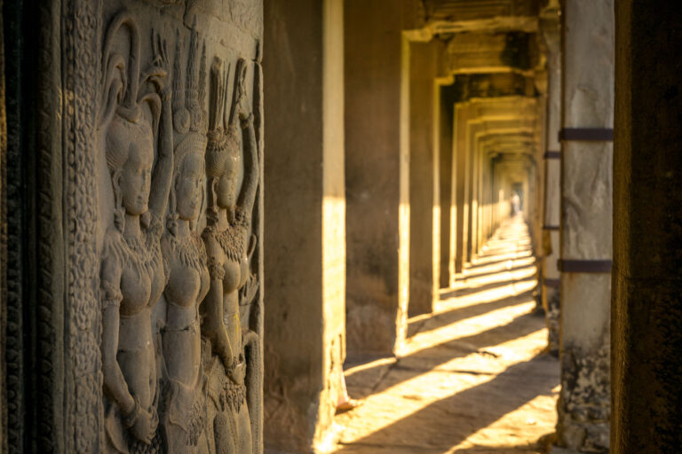 Early morning light falling across the stone bas-reliefs inside Angkor Wat's outer galleries.