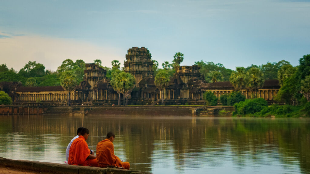 Angkor Wat across the moat at the main western entrance, with Buddhist monks in the foreground