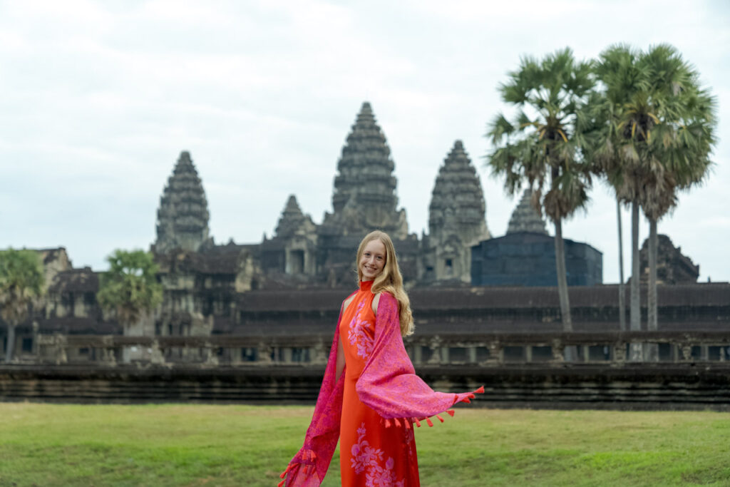 lady in a red dress in front of angkor wat