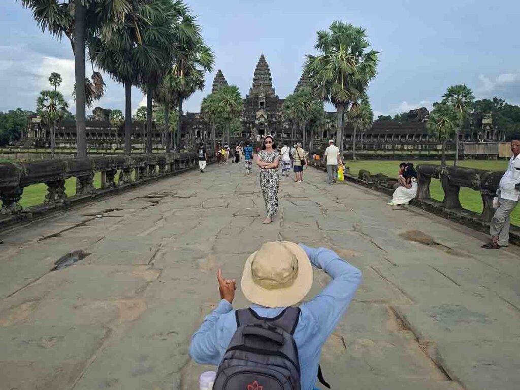 Local photographer taking a picture of a tourist on the main causeway of Angkor Wat