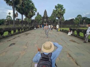 Local photographer taking a picture of a tourist on the main causeway of Angkor Wat